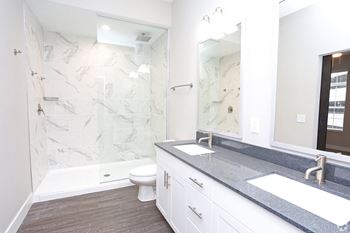 a bathroom with a shower and a sink and a mirror at Century Baxter Avenue, Kentucky, 40204